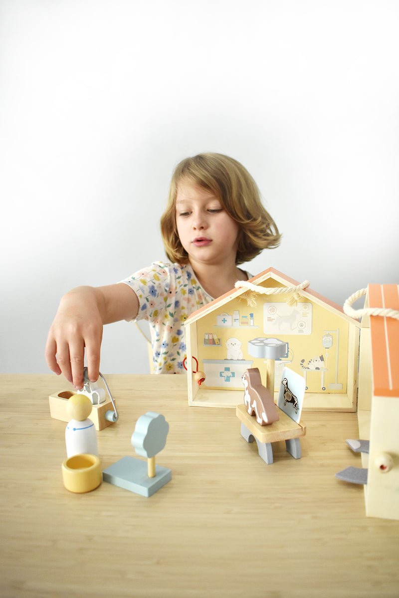 Wooden portable veterinary pet hospital playset by Kaper Kidz featuring a miniature vet clinic, animal figures, and medical accessories.