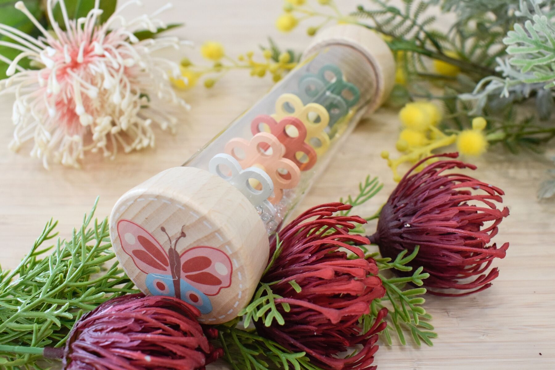 Kaper Kidz spring insect rainmaker rattles featuring butterfly and bee designs, made of wood, for sensory play and music exploration.